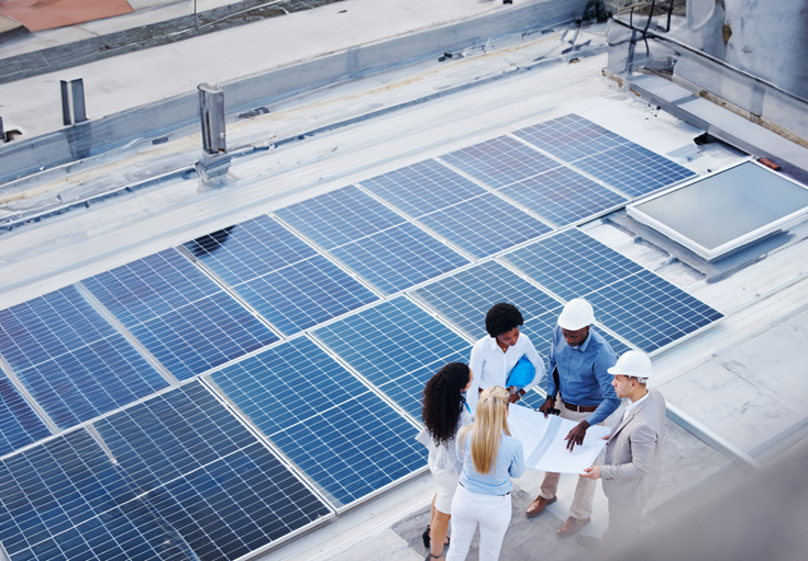 A group of people standing around solar panels